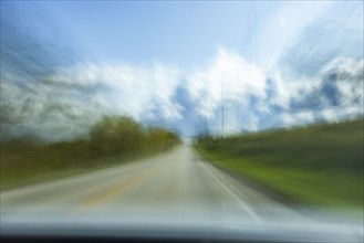 USA, Wisconsin, Country road and clouds seen from moving car, Mt. Horeb, Wisconsin, USA