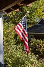 American flag outside house in sunlight, Mt. Horeb, Wisconsin, USA