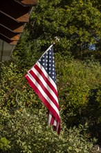 American flag outside house in sunlight, Mt. Horeb, Wisconsin, USA