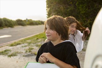 South Africa, Hermanus, Portrait of boy with surfboard and sister on beach, Hermanus, , South