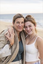 Portrait of smiling mother and teenage daughter on beach, Pescadero, Baja, Mexcio