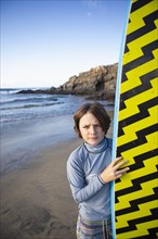 Mexico, Baja, Pescadero, Portrait of boy with surfboard on beach, Pescadero, Baja, Mexcio