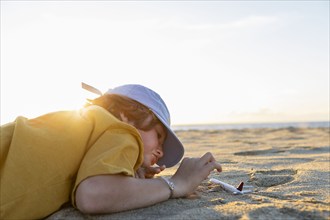 Mexico, Baja, Pescadero, Boy playing with toy airplane on beach, Pescadero, Baja, Mexcio