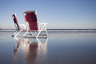 USA, Maine, York, Two beach chairs on wet sand beach, York, Maine, USA