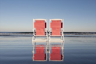 USA, Maine, York, Two beach chairs on wet sand beach, York, Maine, USA