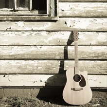 USA, Tennessee, Nashville, Acoustic guitar leaning against wooden house, Nashville, Tennessee, USA