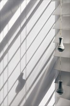 Close-up of white window blinds and shadows, New York City, New York, USA