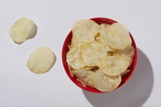 Overhead view of potato chips in bowl on white background, New York City, New York, USA