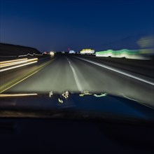 Highway at night seen from moving vehicle, blurred motion, Twin Falls, Idaho, USA