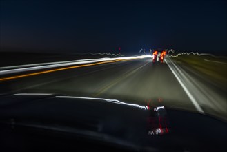 Highway at night seen from moving vehicle, blurred motion, Twin Falls, Idaho, USA