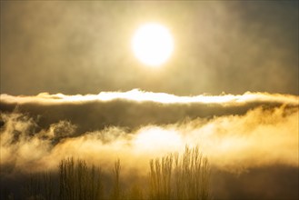 Morning sun bursting through cloudbank, Picabo, Idaho, USA