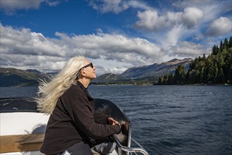 Woman with long white hair on boat on Lake Nahuel Huapi, Bariloche, Rio Negro, Argentina