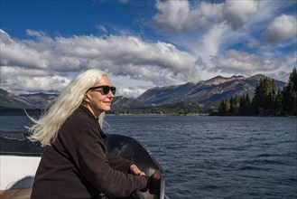 Woman with long white hair on boat on Lake Nahuel Huapi, Bariloche, Rio Negro, Argentina