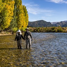 Rear view of senior couple flyfishers wading in Traful River, Estancia Arroyo Verde, Nequen