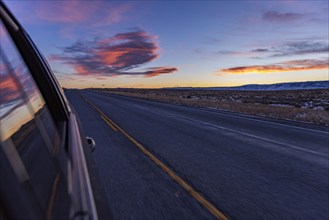 Blurred rural highway seen from moving car at dusk, Twin Falls, Idaho, USA