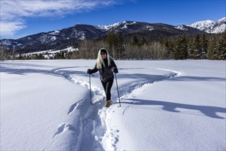 Smiling woman snowshoeing in winter landscape, Sun Valley, Idaho, USA