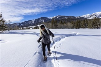 Smiling woman snowshoeing in winter landscape, Sun Valley, Idaho, USA