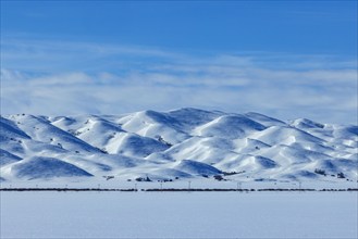 Snow covered field and hills on sunny winter day, Fairfield, Idaho, USA