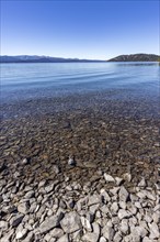 Rocky beach and calm lake on sunny day, Bariloche, , Argentina