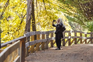 Smiling woman with long white hair photographing landscape with smart phone, Bariloche, Rio Negro,