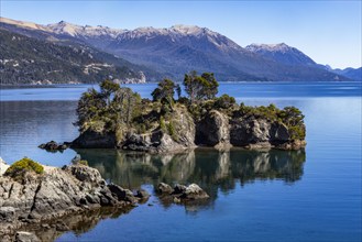 Small rocky island on calm Traful Lake, Estancia Arroyo Verde, Nequen Province, Argentina