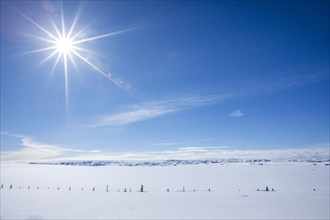 Sun on blue sky over snow covered pastures, Fairfield, Idaho, USA