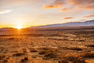 Argentina, Santa Cruz, El Calafate, Sun rising above plain landscape with mountains in distance, El