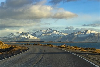 Argentina, Santa Cruz, El Calafate, Empty road with lake and snowcapped mountains in background, El