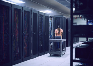 Female technician using laptop in server room 
St, George, Utah, USA