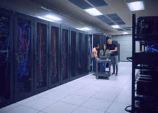 Group of technicians using laptop in server room 
St, George, Utah, USA