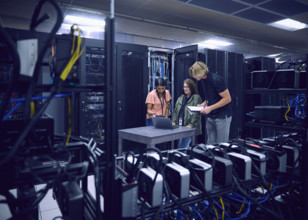 Group of technicians using laptop in server room 
St, George, Utah, USA