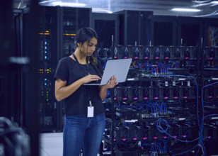 Female technician using laptop in server room 
St, George, Utah, USA