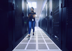 Female technician walking in server room 
St, George, Utah, USA