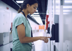 Woman using digital fingerprint scanner in office in server room
St, George, Utah, USA