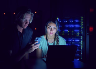 Female and male technicians using laptop in server room 
St, George, Utah, USA