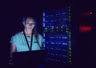 Female technician using laptop in server room 
St, George, Utah, USA