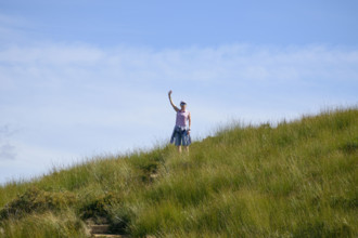 Woman in sunglasses standing on grassy field and waving
Blackheath, New South Wales, Australia