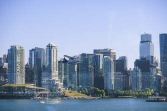 Seaplane flying above Burrard Inlet, downtown buildings in background
Vancouver, British Columbia,