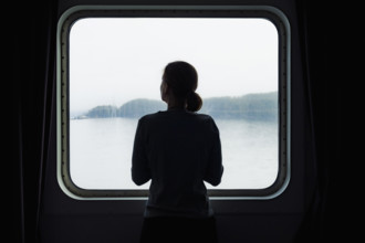 Silhouette of woman standing in front of window in ferry
USA