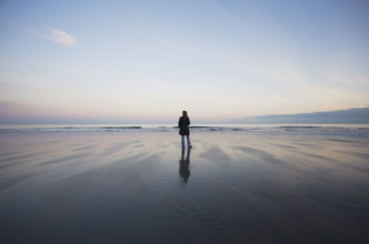 Rear view of woman standing on beach at sunset
York Beach, Maine, USA