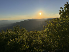 Sun setting above green forested hills
Pembroke, Virginia, USA