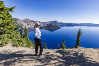 USA, Oregon, Portrait of smiling woman near calm Crater lake
