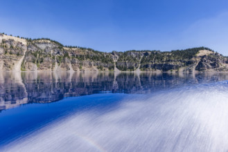 USA, Oregon, Cliffs reflected in calm surface of Crater lake
