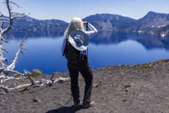 USA, Oregon, Crater Lake, Rear view of woman facing calm Crater lake