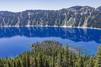 USA, Oregon, Cliffs reflected in calm surface of Crater lake