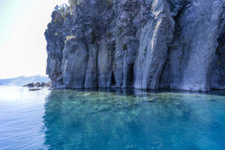 USA, Oregon, Cliff with caves by calm Crater lake