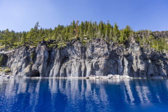 USA, Oregon, Cliff with caves by calm Crater lake