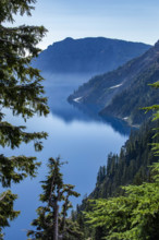 USA, Oregon, Hills reflected in calm, blue Crater lake