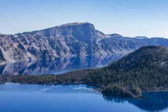 USA, Oregon, Cliffs reflected in calm surface of Crater lake