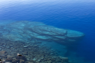 USA, Oregon, Rocks in blue calm Crater Lake